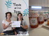 Mariana y Andrea, con el dulce que elaboran y la distinción municipal.