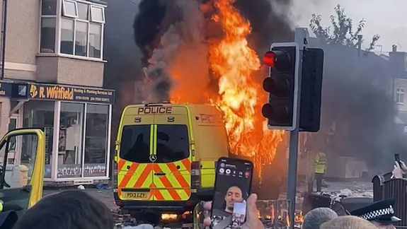 Un movil policial incendiado por manifestantes en Southport