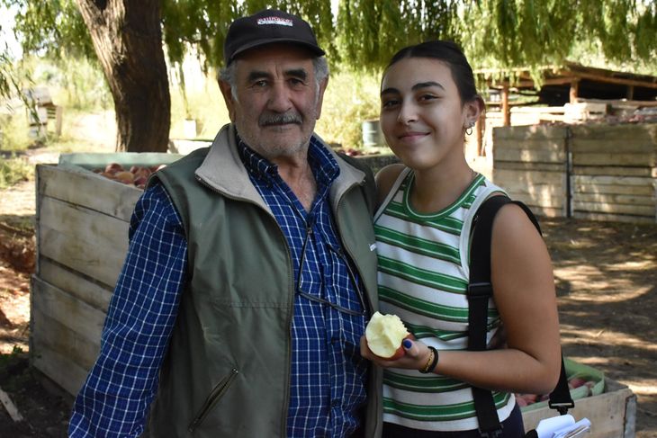 Futuro y tradición: Morela, la nieta de Daniel, recorre la plantación bajo la mirada atenta de su abuelo, en un paisaje marcado por la fe en la fruticultura. Foto: Fabricio González. Futuro y tradición: Morela, la nieta de Daniel, recorre la plantación bajo la mirada atenta de su abuelo, en un paisaje marcado por la fe en la fruticultura. Foto: Fabricio González.