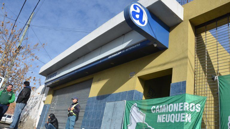 Camioneros impide el ingreso al comercio y un policía custodia.