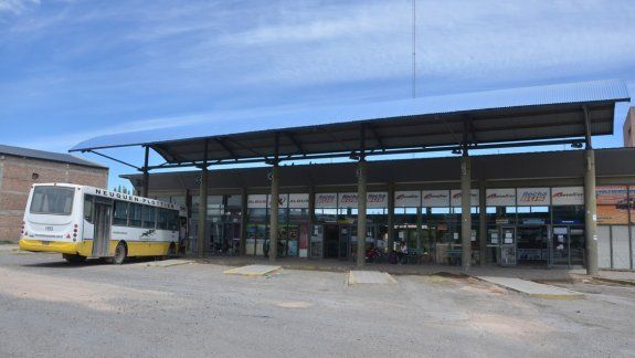 La gente espera el micro al rayo del sol en Plottier