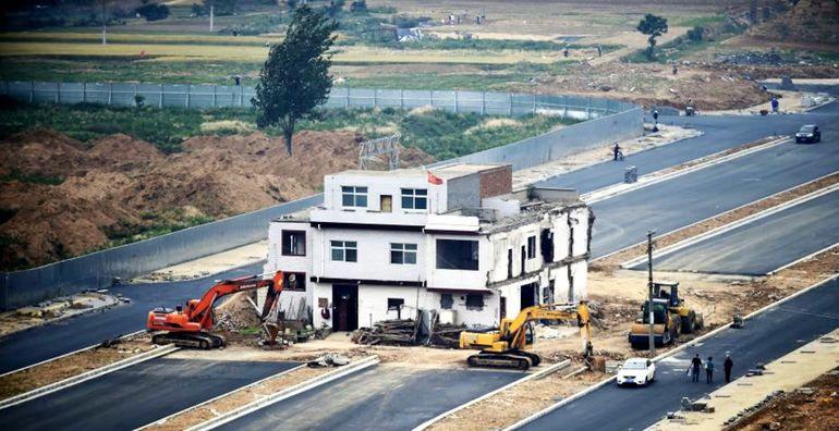 Una casa clavo de tres plantas resiste en mitad de una carretera de Luoyang.