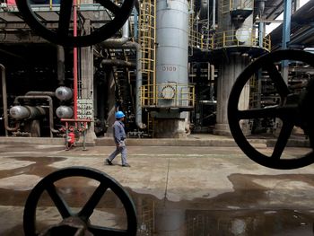 FOTO DE ARCHIVO: Un trabajador camina junto a las tuberías de petróleo en una refinería en Wuhan, provincia de Hubei, China. 23 de marzo 2012. REUTERS/Stringer/Archivo FOTO DE ARCHIVO: Un trabajador camina junto a las tuberías de petróleo en una refinería en Wuhan, provincia de Hubei, China. 23 de marzo 2012. REUTERS/Stringer/Archivo