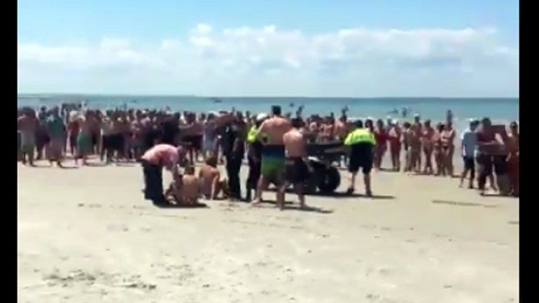 Los cuatro fueron esposados en la playa mientras una multitud los miraba.